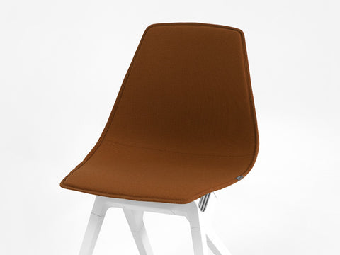 Earth colored New Zealand Wool topper on a white noho move chair